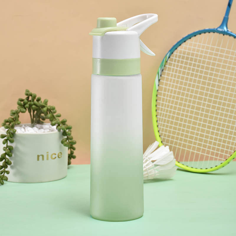 Gradient water bottle with a plant and badminton racket on a green surface