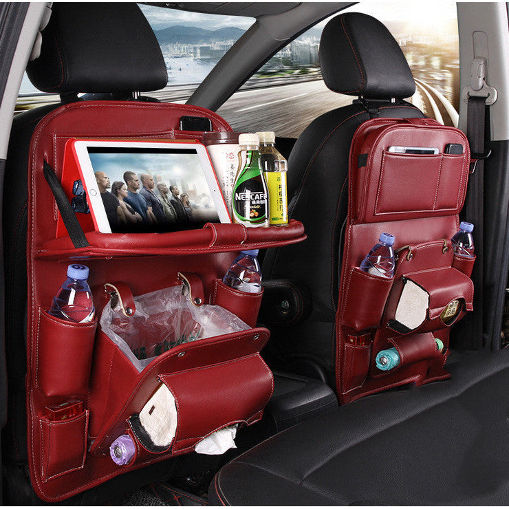 Red car seat organizer with multiple pockets and a tablet holder, placed on a car seat.