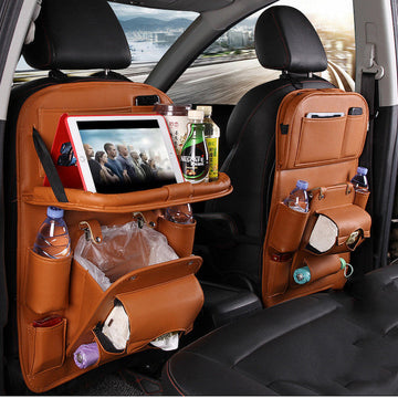 Car back seat organizer with multiple pockets and a tablet holder, filled with items.