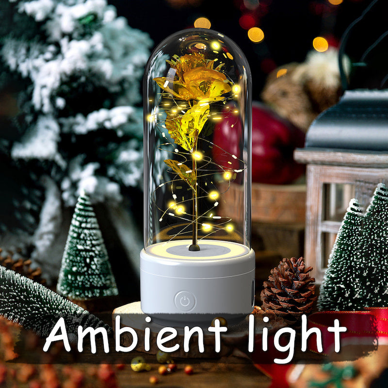 Decorative lamp with glowing yellow flowers under a glass dome on a festive background.