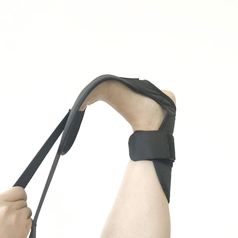 Black arm sling being worn on a person's arm with a white background