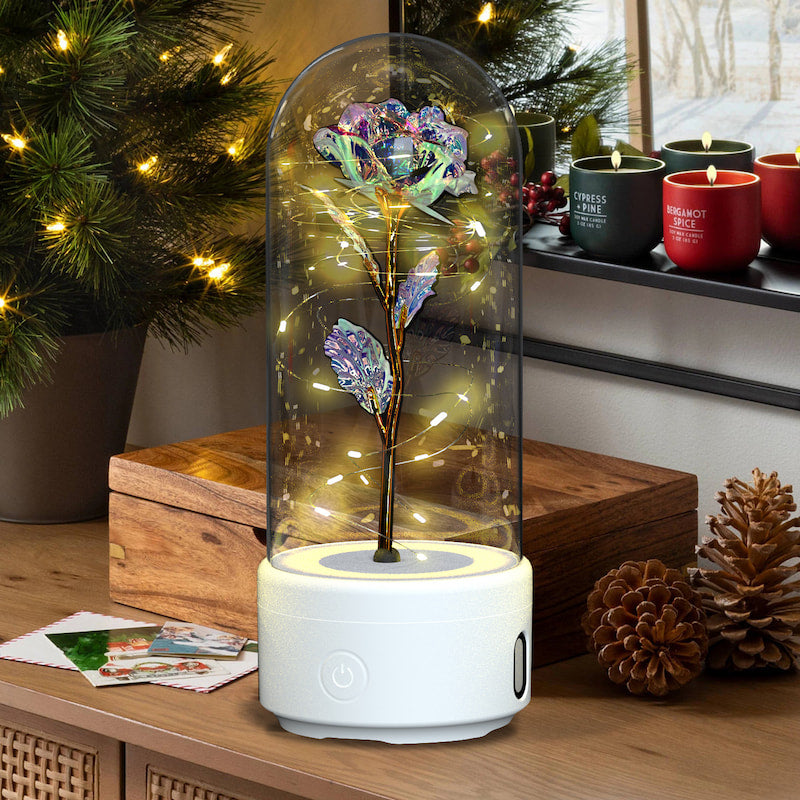 Decorative lamp with a glowing flower inside a glass dome on a wooden surface.