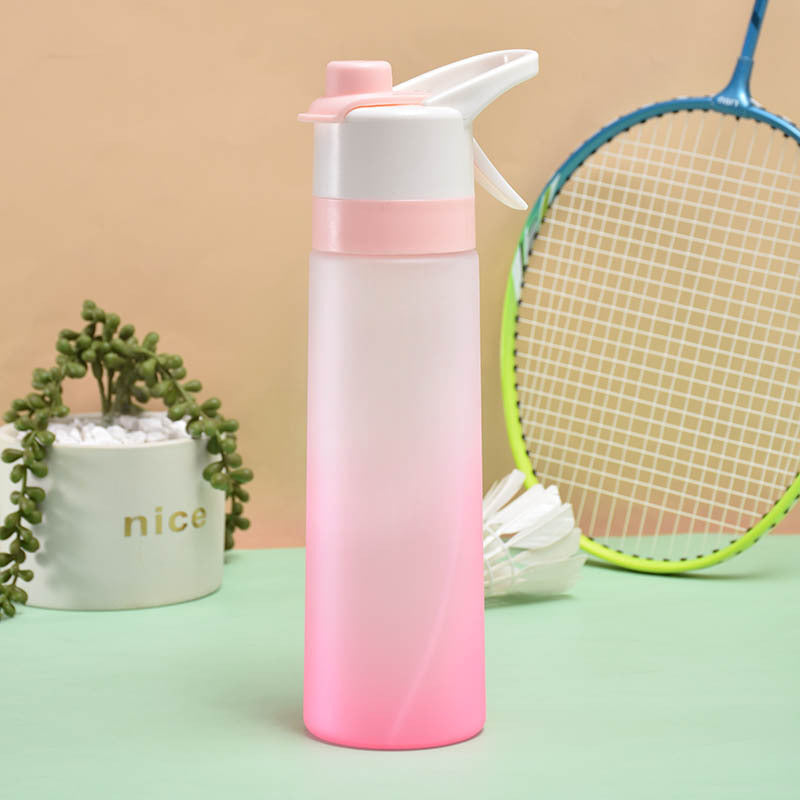 Gradient pink and white water bottle with a plant and badminton racket in the background