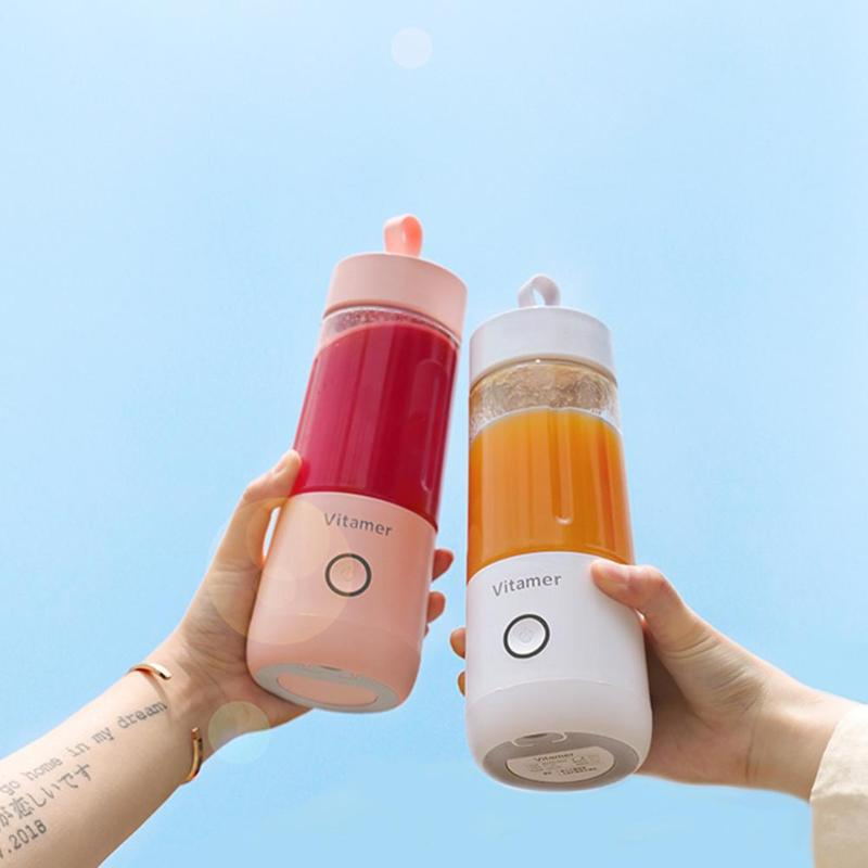 Two portable blenders with colorful drinks against a clear blue sky.